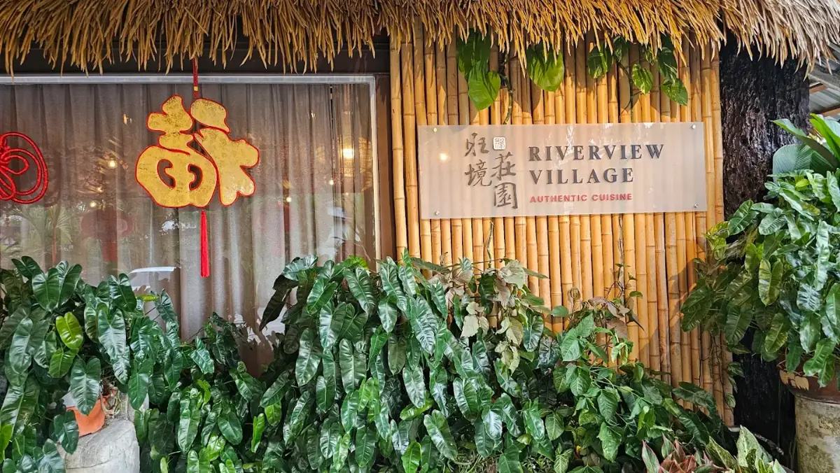 Riverview Village sign on a bamboo wall at the restaurant entrance
