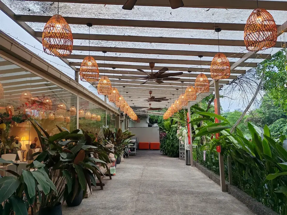 Covered walkway lined with woven rattan lanterns and tropical plants