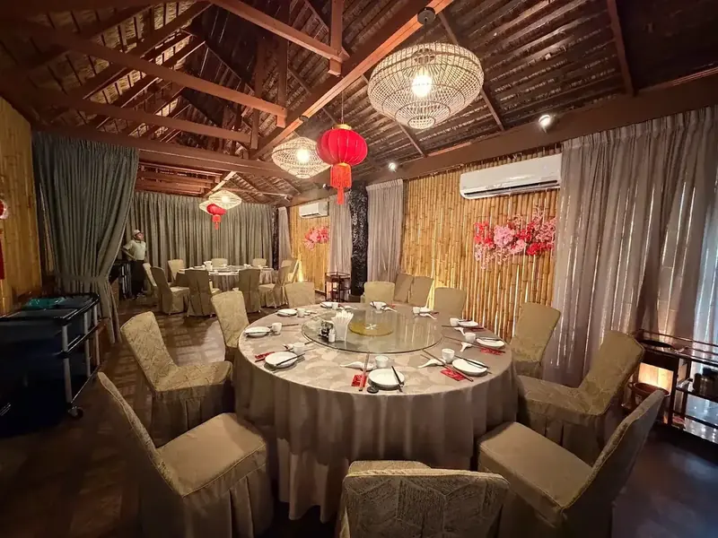 Private dining room with bamboo walls, lanterns and a large round table